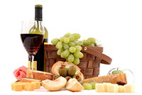 picnic basket with green grapes bottle of red wine with glass and bread