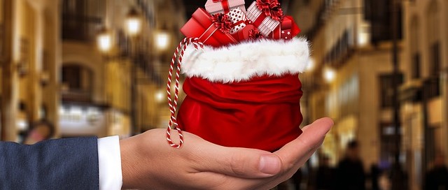 hand holding red santa bag full of presents