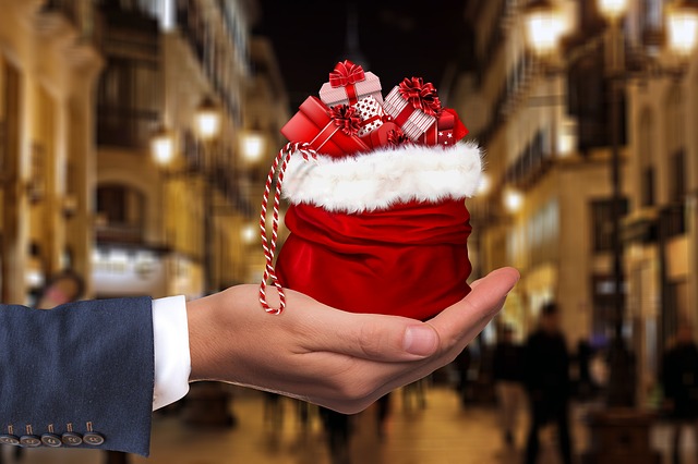 hand holding red santa bag full of presents