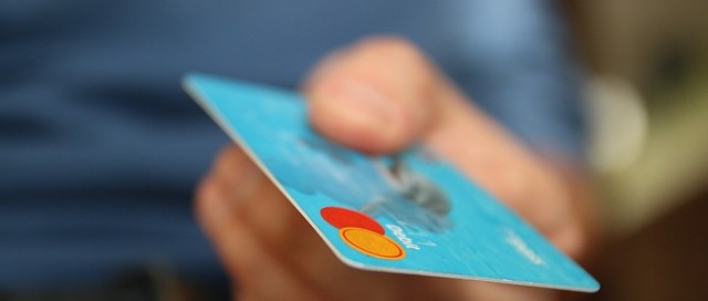 mans hand holding blue credit card