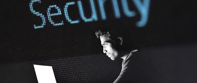 hacker over computer in dark security typed above