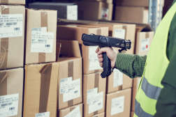 Warehouse Management System. Worker with barcode scanner man's hand holding scanner scanning inventory