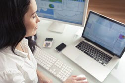 inventory-management woman sitting at desk on laptop