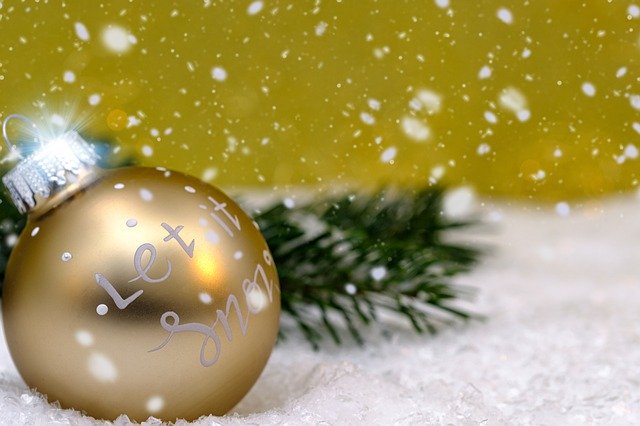 gold christmas ornament with let it snow snowing background