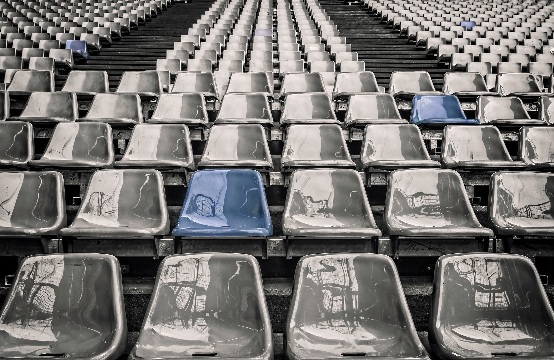 grey-stadium-seats-with-two-blue-seats