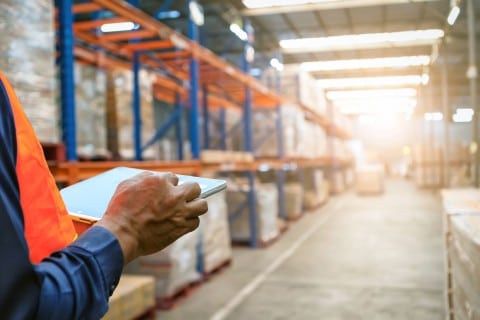 man with laptop in warehouse