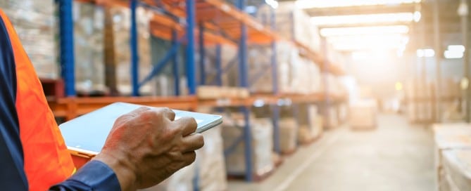 man with laptop in warehouse